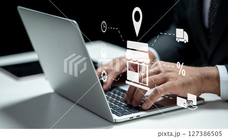 Businessman using a laptop while showing an icon of a shop for ecommerce. Tablet on the table. Technology innovation on a virtual screen. Concept of ecommerce or small business Businessman using a laptop while showing an icon of a shop for ecommerce. Tablet on the table. Technology innovation on a virtual screen. Concept of ecommerce or small business 127386505
