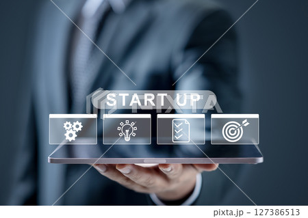 Businessman is showing an icon of a startup on the tablet screen. Technology innovation on a virtual screen. Concept of business startup Businessman is showing an icon of a startup on the tablet screen. Technology innovation on a virtual screen. Concept of business startup 127386513