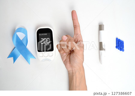 Human hand showing its finger with a kit for checking blood sugar level isolated over a white background. Concept of diabetes or a healthy lifestyle 127386607