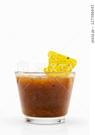 Nachos tortilla chips on salsa barbecue sauce in a glass bowl on a white background. Food and snacks concept 127386645