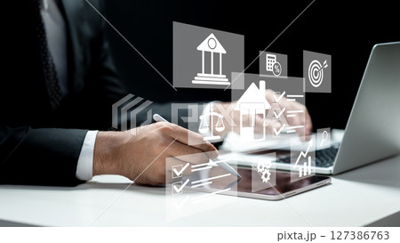 Businessman using a laptop and tablet and showing an icon of a financial loan scheme. Technology innovation on a virtual screen. Concept of a financial loan 127386763