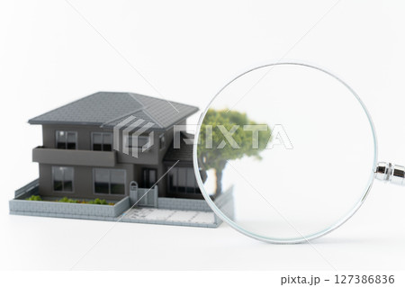白背景に虫眼鏡とミニチュアの一戸建て住宅 白背景に虫眼鏡とミニチュアの一戸建て住宅 127386836