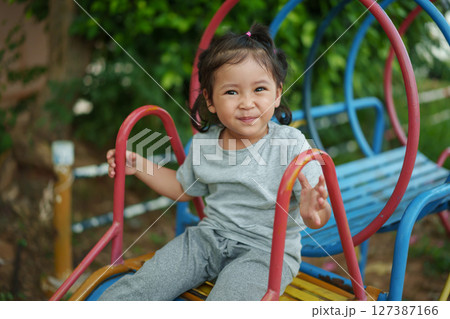 happy toddler baby girl sliding and playing at playground happy toddler baby girl sliding and playing at playground 127387166