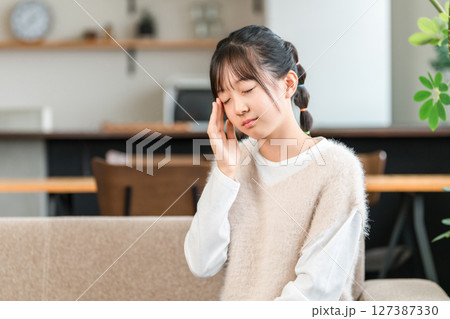 頭痛でこめかみを抑える小学生,中学生の女の子 127387330