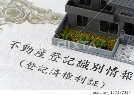 ミニチュアの一戸建て住宅と不動産登記識別情報(登記済権利証) ミニチュアの一戸建て住宅と不動産登記識別情報(登記済権利証) 127387334