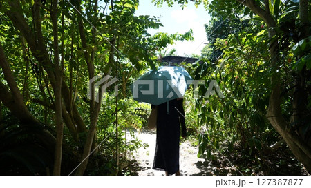 由布島の細い道を歩く女性 127387877