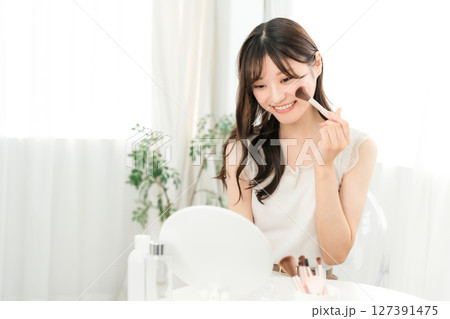 チークブラシ,フェイスブラシでメイクする若いアジア人女性 127391475