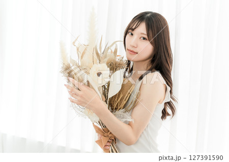 ドライフラワーのスワッグを持つおしゃれな女性 ドライフラワーのスワッグを持つおしゃれな女性 127391590