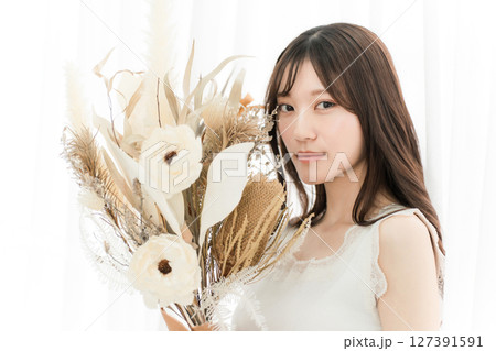 ドライフラワーのスワッグを持つおしゃれな女性 127391591