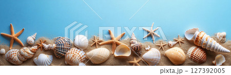 Seashells and starfish decorate the sandy beach under clear skies, created with Generative AI 127392005