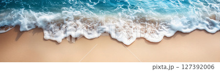 Gentle waves lap against the warm sand under a vibrant summer sky, created with Generative AI 127392006
