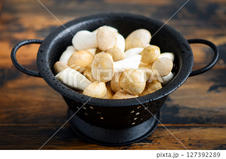 Fresh raw Eringi or King Trumpet mushrooms on a wooden table. 127392289