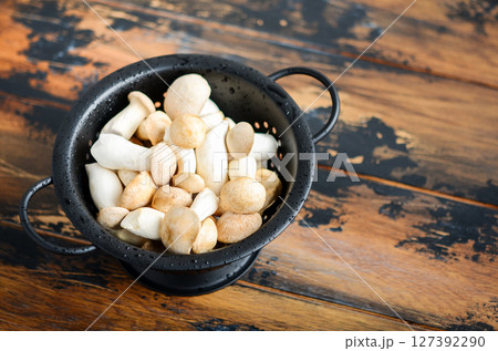 Fresh raw Eringi or King Trumpet mushrooms on a wooden table. Fresh raw Eringi or King Trumpet mushrooms on a wooden table. 127392290
