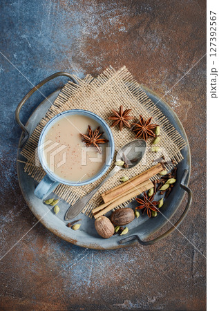 Indian masala chai tea. Spiced tea with milk on dark rusty background. Indian masala chai tea. Spiced tea with milk on dark rusty background. 127392567