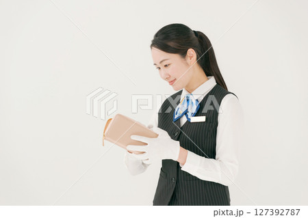 手袋をしてブランド製品の査定をする女性 127392787