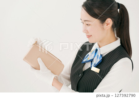 手袋をしてブランド製品の査定をする女性 手袋をしてブランド製品の査定をする女性 127392790