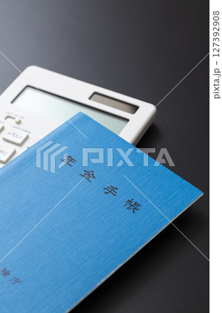 黒背景に電卓と年金手帳 127392908