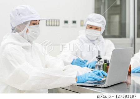 薬品工場,製薬会社で薬品開発をするクリーンスーツを着たスタッフ 127393197