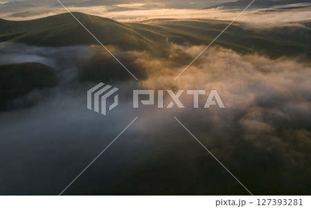 Aerial drone view of foggy sunrise over hills 127393281