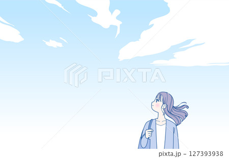 青空の下に立つ横向きの若い女性 127393938