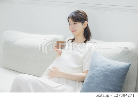 部屋で飲み物を飲む妊婦　 127394271