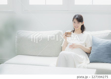 部屋で飲み物を飲む妊婦　 127394275