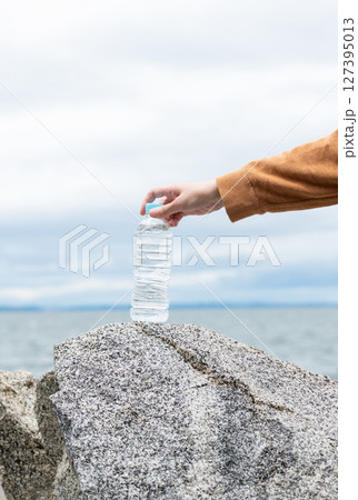 ペットボトルの水を持っている人 127395013