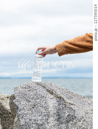 ペットボトルの水を持っている人 127395014