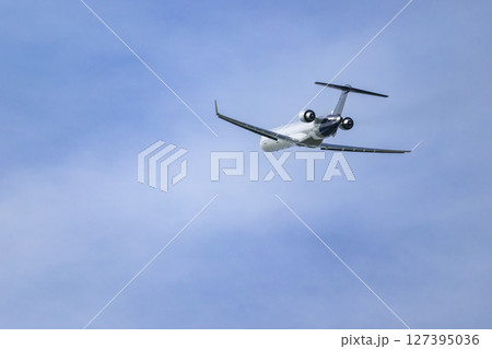 Passenger airplane flying in a clear blue sky over Hostivice, Czechia Passenger airplane flying in a clear blue sky over Hostivice, Czechia 127395036