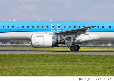 Embraer 195 airplane taxiing on runway at Amsterdam Airport Schiphol in Netherlands 127395052