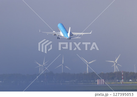 airplane taking off over wind turbines at Amsterdam Schiphol Airport 127395053