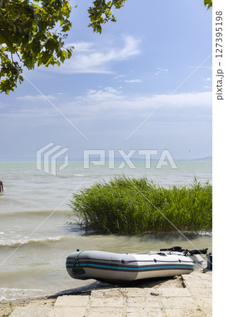 Inflatable boat resting on Lake Balaton shore in Paloznak, Hungary Inflatable boat resting on Lake Balaton shore in Paloznak, Hungary 127395198