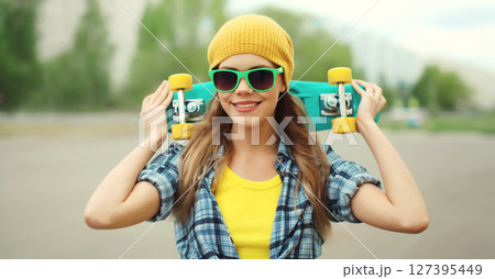 Stylish young woman with skateboard smiles, happy modern teenage girl posing outdoors 127395449