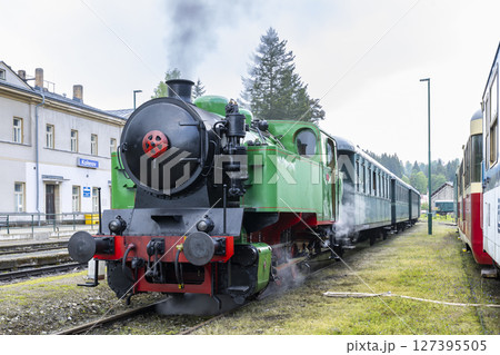 Vintage steam train departing from Korenov station in Czechia, Liberecky kraj 127395505