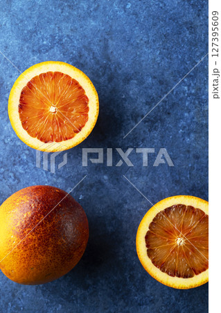 Blood oranges lying on a blue textured background 127395609