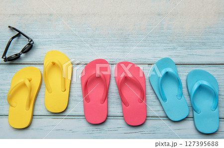 Colorful flip flops and sunglasses resting on beach boardwalk, embracing summer vibes 127395688