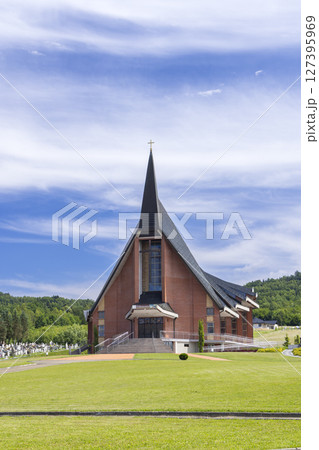 Modern Church Building with Steeple Reaching for the Blue Sky in Jasienica Rosielna, Poland Modern Church Building with Steeple Reaching for the Blue Sky in Jasienica Rosielna, Poland 127395969