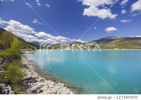 Turquoise waters of Castillon Lake reflecting the blue sky in Castellane, France Turquoise waters of Castillon Lake reflecting the blue sky in Castellane, France 127395970