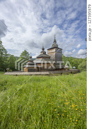 Saint Michael Archangel's Church in Sekowa standing in green meadow under cloudy sky Saint Michael Archangel's Church in Sekowa standing in green meadow under cloudy sky 127395979