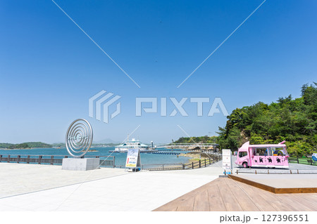 青空を背景に映える海に浮かぶ水族館と周辺施設風景「天草パールガーデン& 海中水族館シードーナツ」 127396551