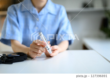 Close up of female hands preparing for blood glucose test, healthcare and wellness concept 127396891