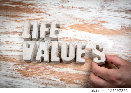 Life Values. Concrete alphabet letters on a light painted wood texture background Life Values. Concrete alphabet letters on a light painted wood texture background 127397223