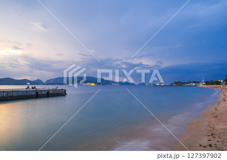 View of Vinpearl Island in Nha Trang in Vietnam in the sea at sunrise in the cloudy morning. Long exposure landscape View of Vinpearl Island in Nha Trang in Vietnam in the sea at sunrise in the cloudy morning. Long exposure landscape 127397902