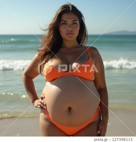 Radiating confidence and joy, a pregnant woman stands gracefully at the water's edge, surrounded by gentle waves and soft sunlight, capturing a moment of serene beauty Generative AI 127398113