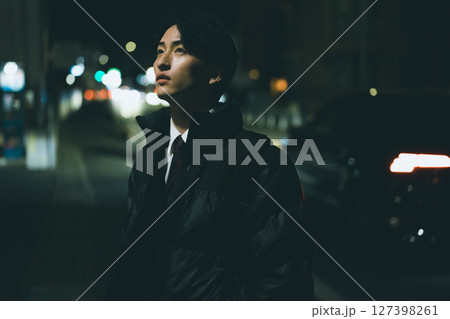 夜の街を歩く男性 127398261
