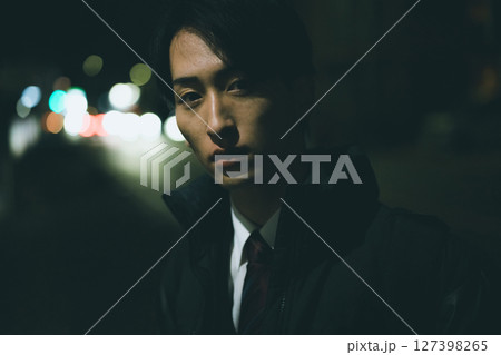 夜の街を歩く男性 127398265