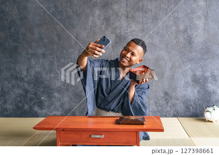 日本料理店で鰻重の写真を撮る黒人男性 127398661