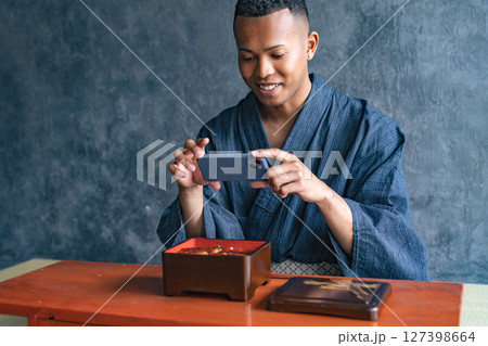 日本料理店で鰻重の写真を撮る黒人男性 日本料理店で鰻重の写真を撮る黒人男性 127398664