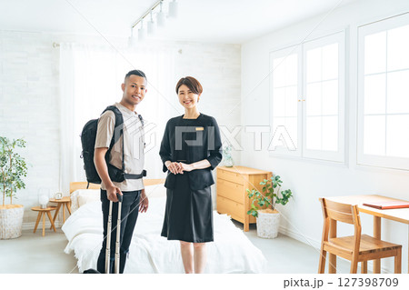 黒人男性旅行客に部屋を案内する女性ホテルスタッフ 127398709