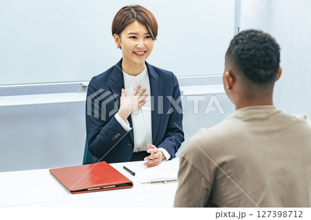 黒人男性と面談する日本人女性スタッフ 127398712